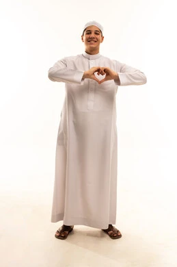 رجل سعودي بالثوب التقليدي يصنع علامة القلب