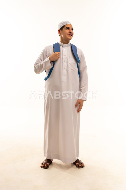 طالب عربي بالثوب الأبيض مع حقيبة ظهر زرقاء