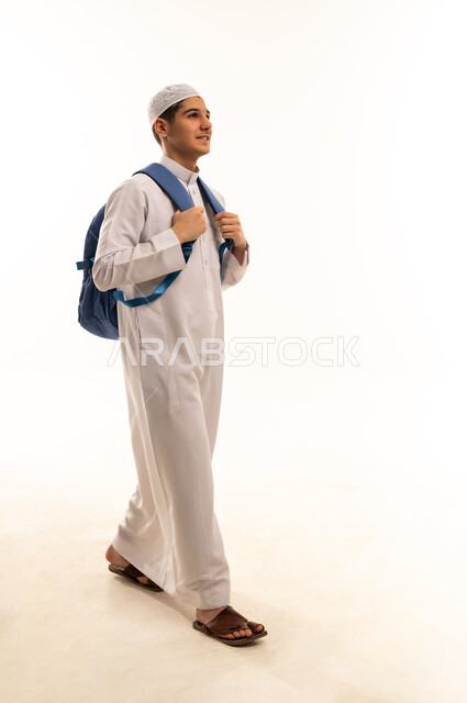 طالب عربي يمشي بحقيبة ظهر بالثوب الأبيض