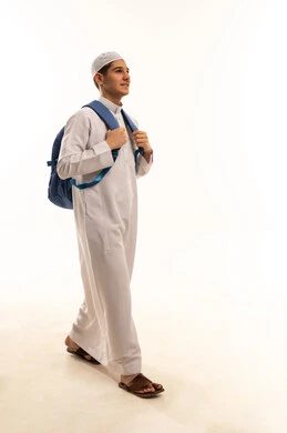 طالب عربي يمشي بحقيبة ظهر بالثوب الأبيض