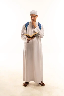 A Saudi student is reading a book against a white background.