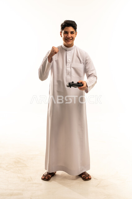 شاب سعودي يحمل جهاز تحكم ألعاب ويحتفل بالفوز