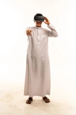 رجل سعودي يستخدم سماعة الواقع الافتراضي بخلفية بيضاء