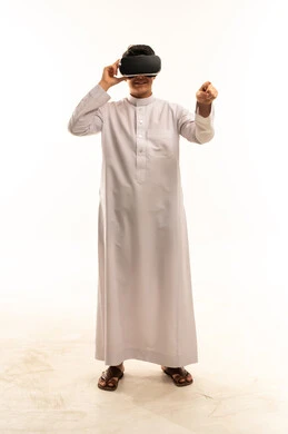 شاب سعودي بالثوب يستخدم نظارات الواقع الافتراضي