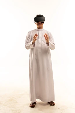 رجل سعودي بالثوب يستخدم نظارات الواقع الافتراضي