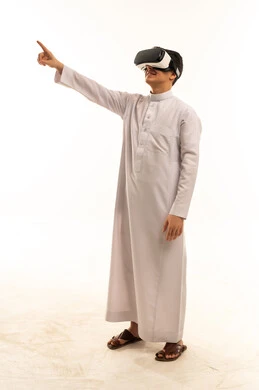 Saudi Man in Thobe Using VR Headset on White Background