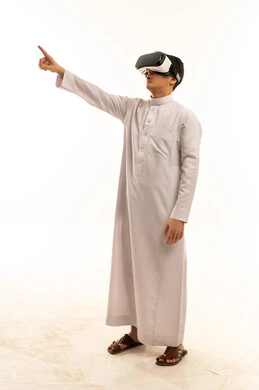 رجل سعودي بالثوب يستخدم نظارات الواقع الافتراضي