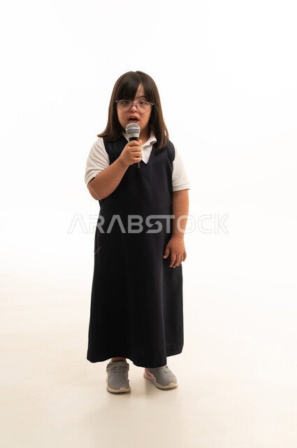 طفلة سعودية من ذوي متلازمة داون تمسك ميكروفون