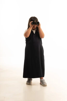 طالبة سعودية بالزي المدرسي تستخدم المنظار خلفية بيضاء