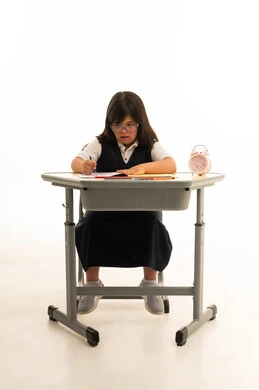 طفلة عربية من ذوي متلازمة داون تدرس على مكتب