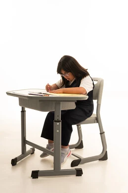 طالبة سعودية من ذوي متلازمة داون تكتب على المكتب