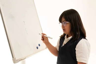 طفلة سعودية من ذوي متلازمة داون تكتب على السبورة