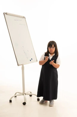 فتاة سعودية من ذوي متلازمة داون بجانب السبورة