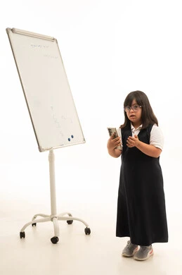 طالبة سعودية من ذوي متلازمة داون مع سبورة بيضاء