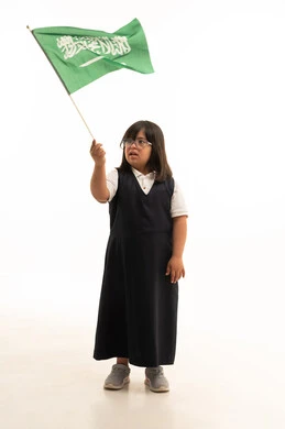طفلة سعودية من ذوي متلازمة داون تحمل علم السعودية