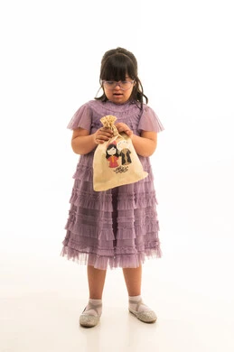 طفلة سعودية من ذوي متلازمة داون مع كيس هدايا طفلة سعودية من ذوي متلازمة داون مع كيس هدايا