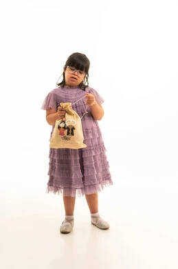 طفلة عربية بمتلازمة داون ترتدي فستان أرجواني