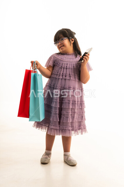 طفلة سعودية بمتلازمة داون مع حقائب تسوق وهاتف