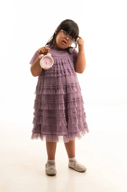 طفلة سعودية من ذوي متلازمة داون تحمل منبهاً وردياً