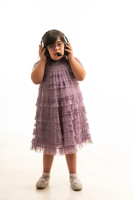 طفلة عربية من متلازمة داون ترتدي سماعات رأس