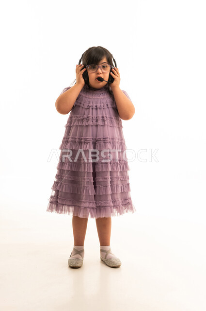 طفلة عربية من ذوي متلازمة داون ترتدي سماعة رأس