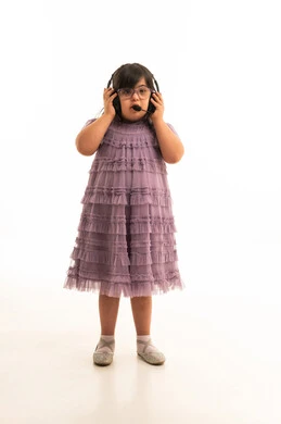 طفلة عربية من ذوي متلازمة داون ترتدي سماعة رأس