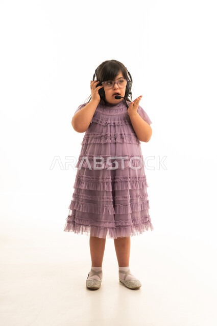 طفلة عربية من ذوي الاحتياجات الخاصة ترتدي سماعة رأس