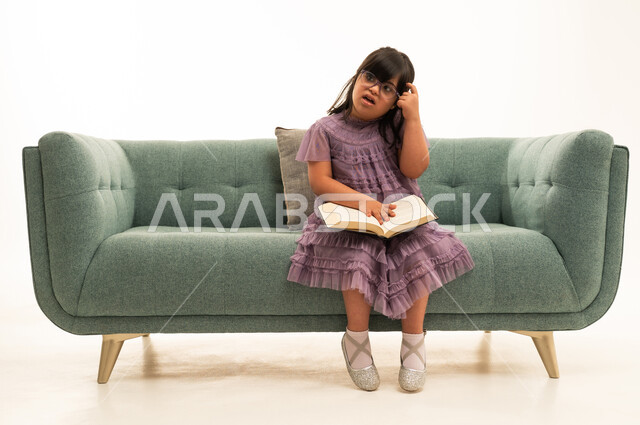 طفلة عربية من ذوي متلازمة داون تقرأ كتاباً