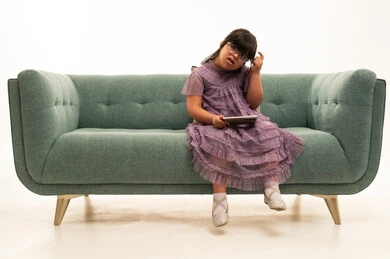 Saudi Girl with Down Syndrome on Sofa with Tablet