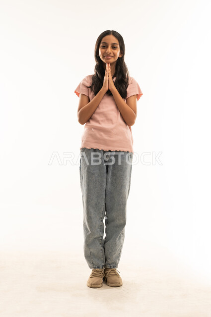 فتاة سعودية بملابس كاجوال مع إيماءة تحية
