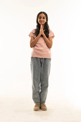 فتاة سعودية بملابس كاجوال مع إيماءة تحية