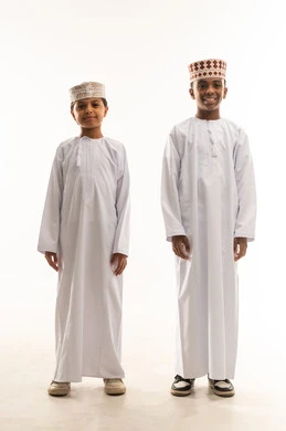 ولدان عمانيان بالزي العماني التقليدي الدشداشة والكمة