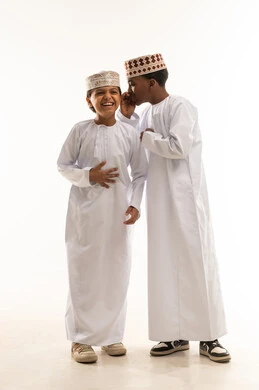 أطفال عمانيون بالزي التقليدي يضحكون معاً