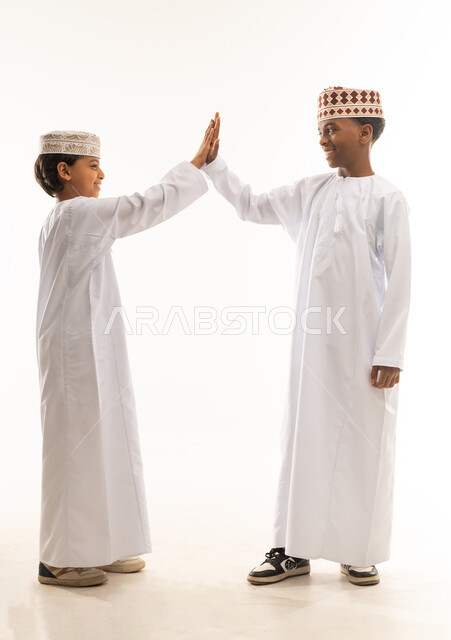 Omani Boys in Traditional Attire Giving High Five