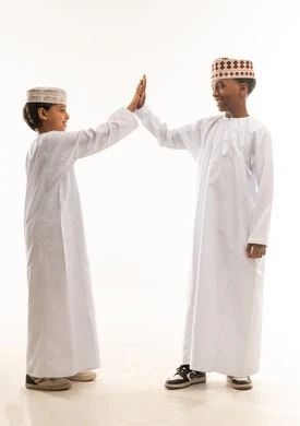Omani Boys in Traditional Attire Giving High Five
