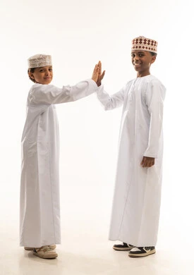 أطفال عمانيون بالزي التقليدي يتبادلون التحية