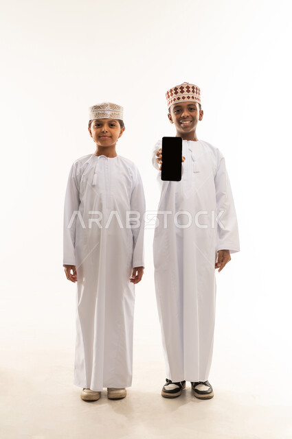 Omani Boys in Traditional Dress Holding Smartphone