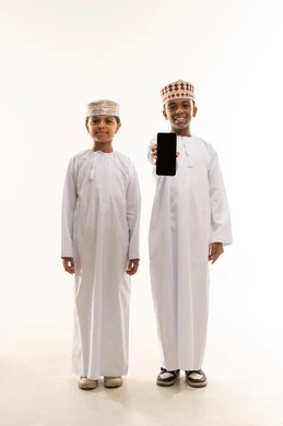 أطفال عمانيون بالزي التقليدي يحملون هاتف ذكي