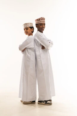 طفلان عمانيان بالدشداشة والكمة العمانية التقليدية