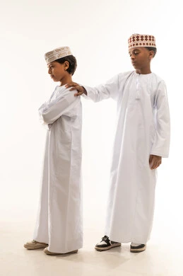 أطفال عمانيون بالزي التقليدي على خلفية بيضاء
