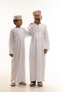 Omani Boys in Traditional Dress Comforting Each Other