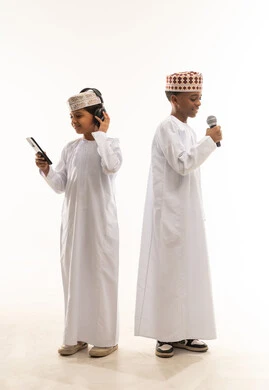 أطفال عمانيون بالزي التقليدي يستخدمون التقنية الحديثة