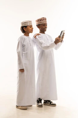 Omani Boys in Traditional Dress Using Tablet Studio
