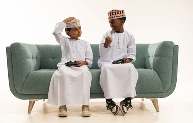 Omani Boys Playing Video Games on Sofa