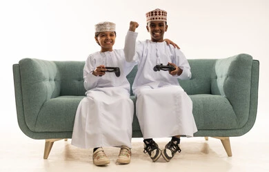 Omani Boys Playing Video Games on Sofa