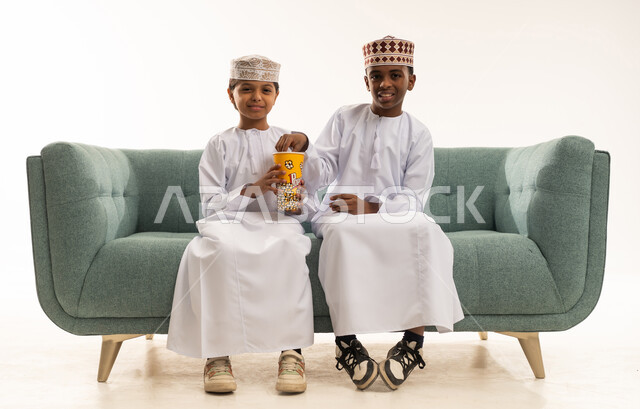 Omani Boys in Traditional Dress Eating Popcorn