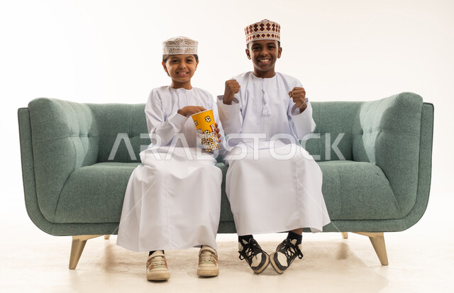 أطفال عمانيون بالزي التقليدي يتناولون الفشار