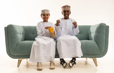 Omani Boys in Traditional Dress Eating Popcorn