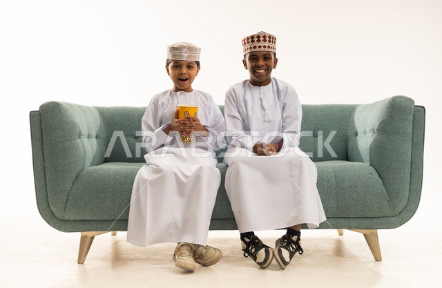 أطفال عمانيون بالزي التقليدي يتناولون الفشار