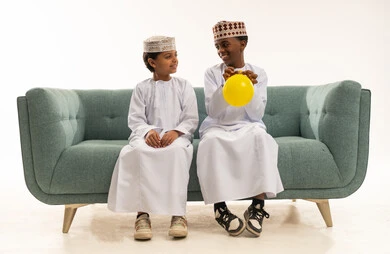 أطفال عمانيون باللباس التقليدي يلعبون بالبالون